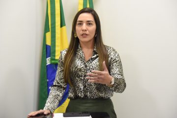 Foto da juíza de Porto Acre, Bruna Perazzo. Ela aparenta ter cerca de 30 anos, é branca, usa blusa com estampa de onça e saia da cor verde-escuro.